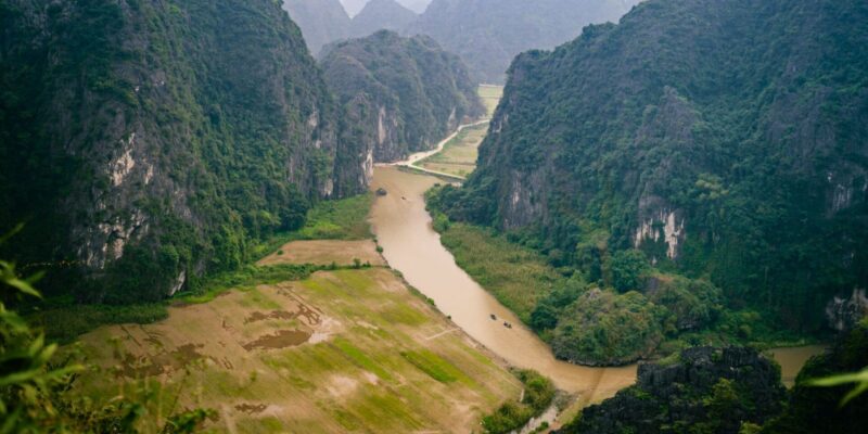 boats navigating a river between lush green mountains